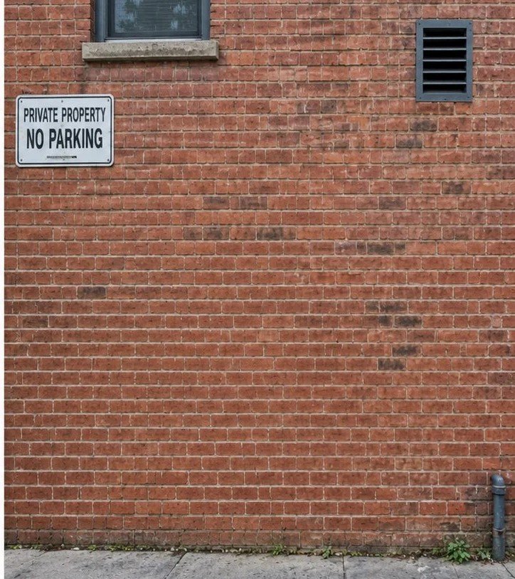 The same brick wall with the graffiti fully removed by laser cleaning