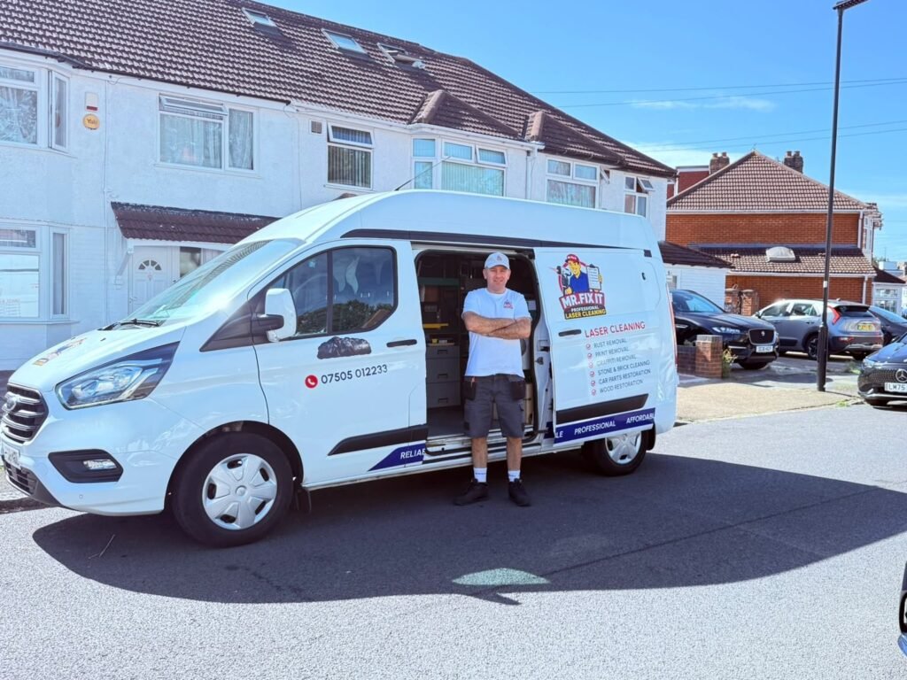 Pawel from Mr Fix It standing at the open side door of his van on a West London street